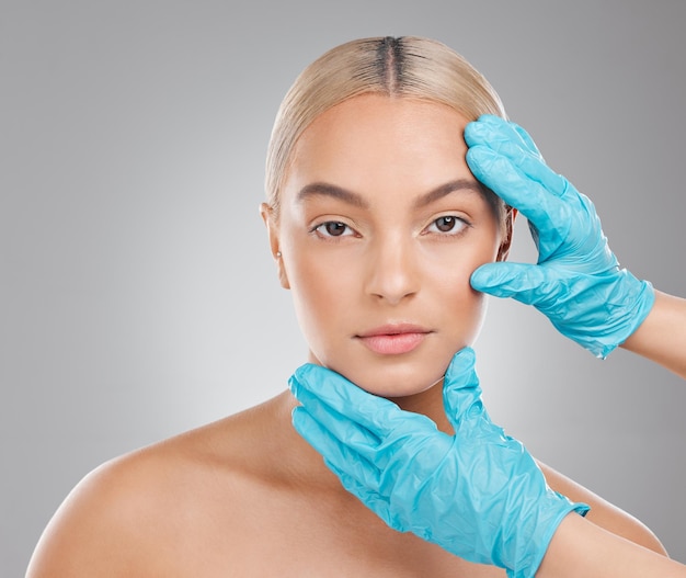 Studio hands and woman for skincare and face gloves and plastic surgery on gray background Beauty cosmetic or medical treatment for selfcare filler or collagen for portrait person for anti aging