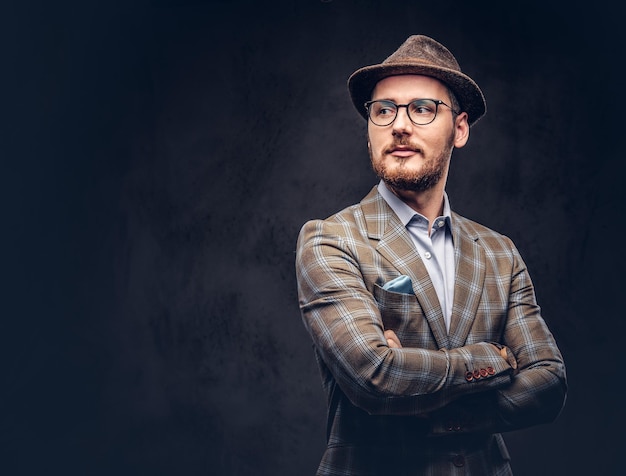 Studio portrait of a bearded hipster in hat and glasses wearing