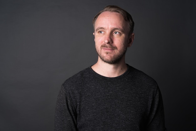 Studio portrait of blonde Caucasian man against gray background