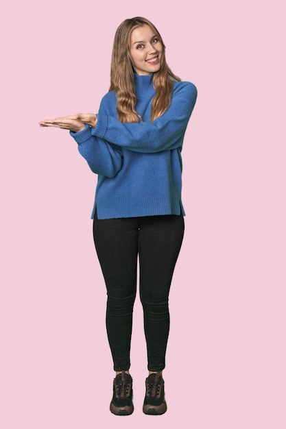 Studio portrait of a blonde Caucasian woman holding a copy space on a palm