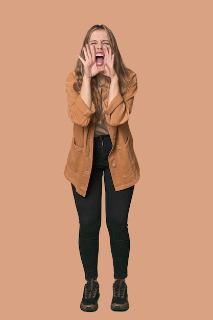 Studio portrait of a blonde Caucasian woman shouting excited to front