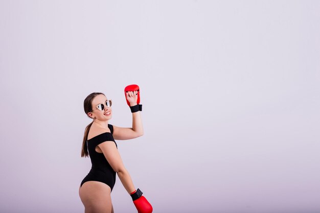 Studio portrait of a boxer female in bodysuit with gloves