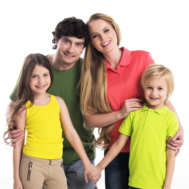 Studio portrait of family in colorful clothes with two children isolated on white surface