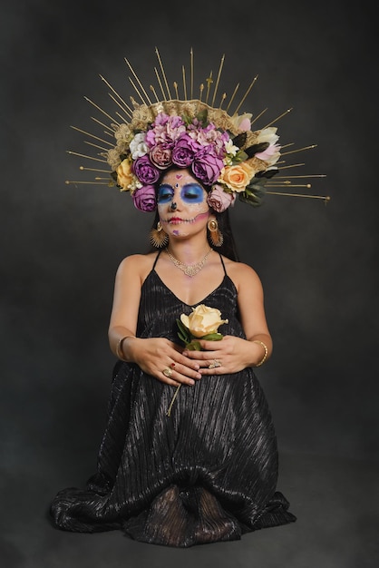 Studio portrait of a girl with catrina makeup seated on the floor