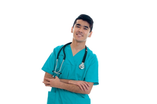 Studio portrait of male doctor in uniform posing isolated on white wall