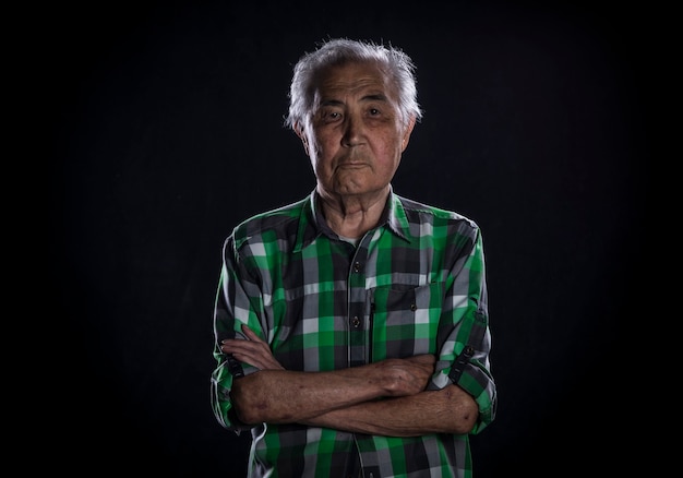 studio portrait of an old man on a black background