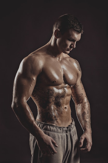 Studio portrait of a shirtless athletic tattooed male