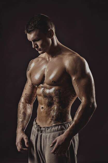 Studio portrait of a shirtless athletic tattooed man