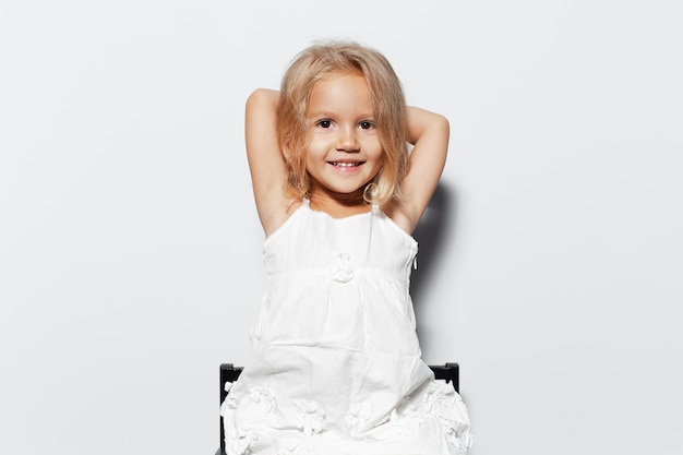 Studio portrait of smiling child girl with blonde hair on white background