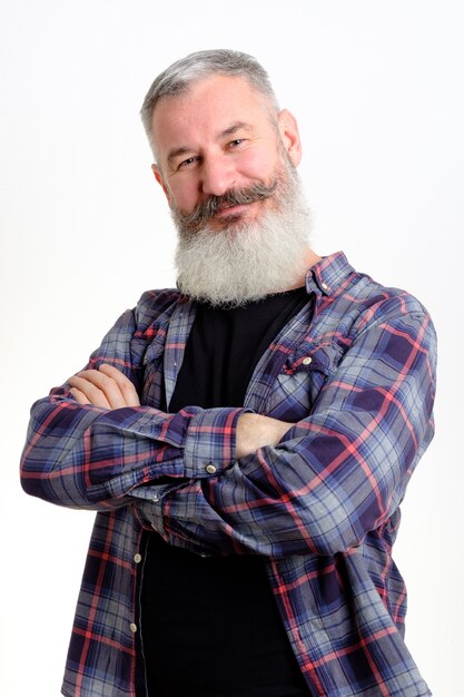 Studio portrait of smiling mature bearded man in casual clothes looking to camera, informal lifestyle, yellow wall.