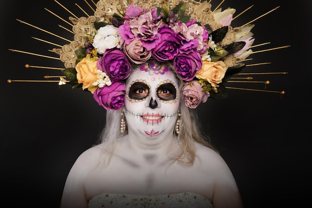 Studio portrait of woman in catrina makeup wearing wedding dress Sugar skull make up