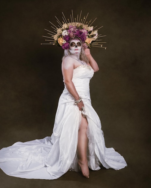 Studio portrait of woman in catrina makeup wearing wedding dress