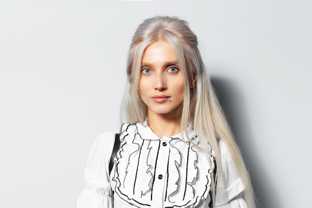 Studio portrait of young blonde cute girl on white background