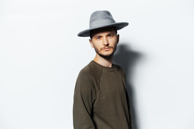 Studio portrait of young man on white background wearing sweater and grey hat