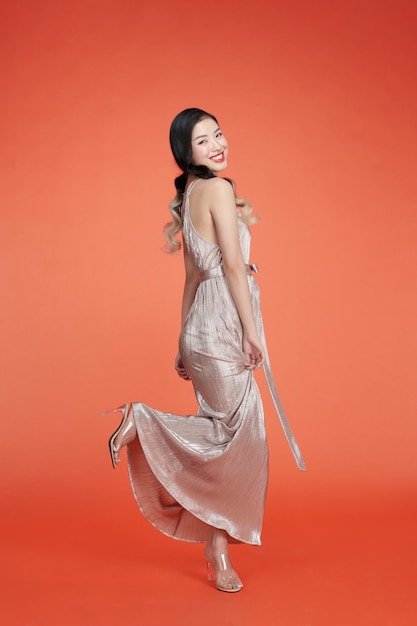 Studio shot of a beautiful young woman in a silver sequined dress dancing