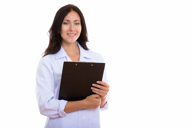 Studio shot of happy beautiful woman doctor smiling while holding a clipboard