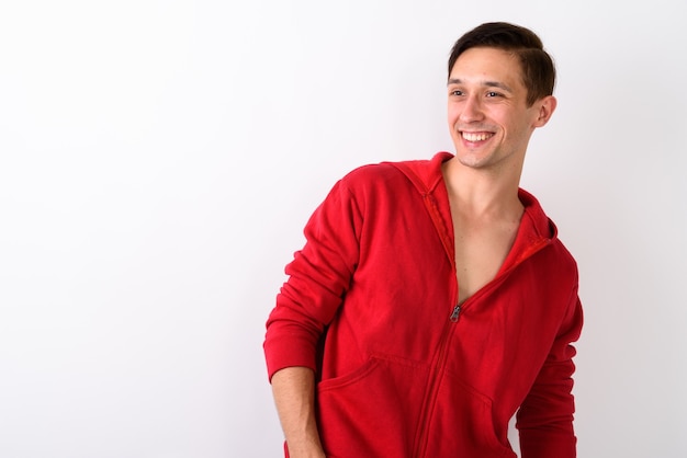 Studio shot of happy young handsome man smiling while looking to