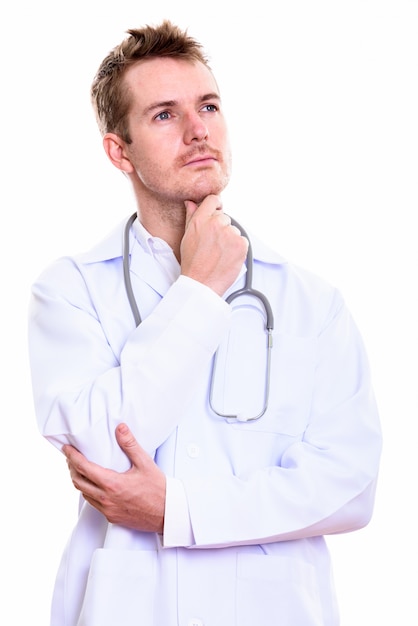 Studio shot of man doctor thinking while looking up