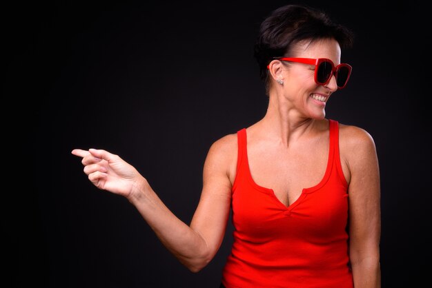 Studio shot of mature beautiful Scandinavian woman with short hair against black background