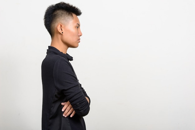 Studio shot of young Asian lesbian woman with short hair against white background