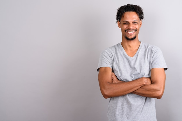 Studio shot of young bearded handsome African man wearing gray shirt against gray background