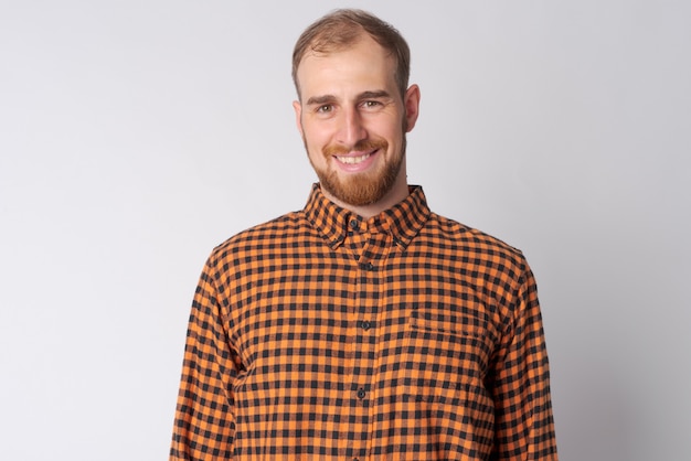 Studio shot of young bearded hipster man against white