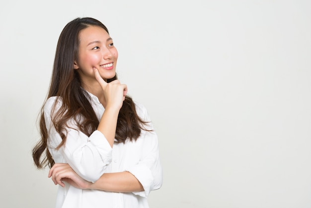 Studio shot of young beautiful Korean businesswoman against white background