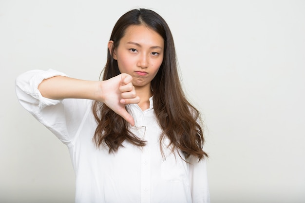 Studio shot of young beautiful Korean businesswoman against white background