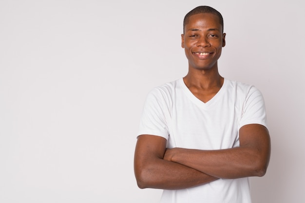 Studio shot of young handsome bald African man against white background