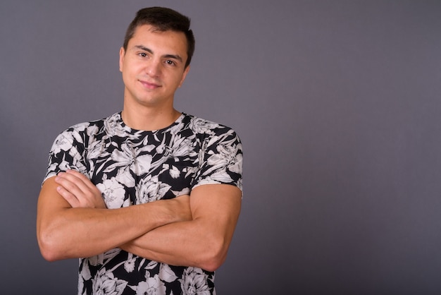 Studio shot of young handsome man against gray background