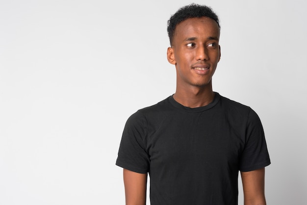 Studio shot of young handsome man with Afro hair against white