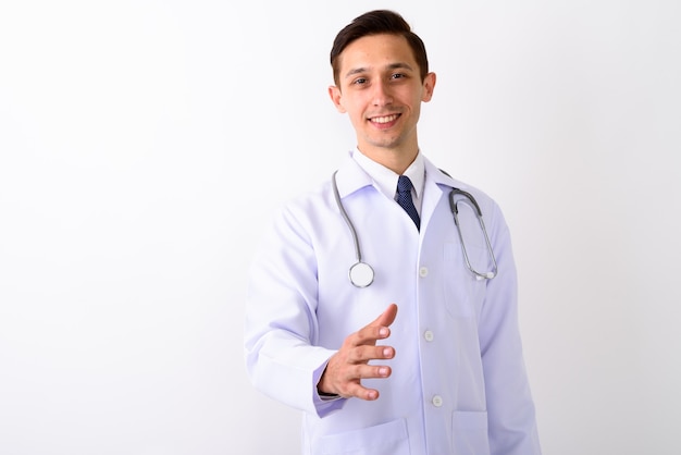 Studio shot of young happy man doctor smiling while giving hands