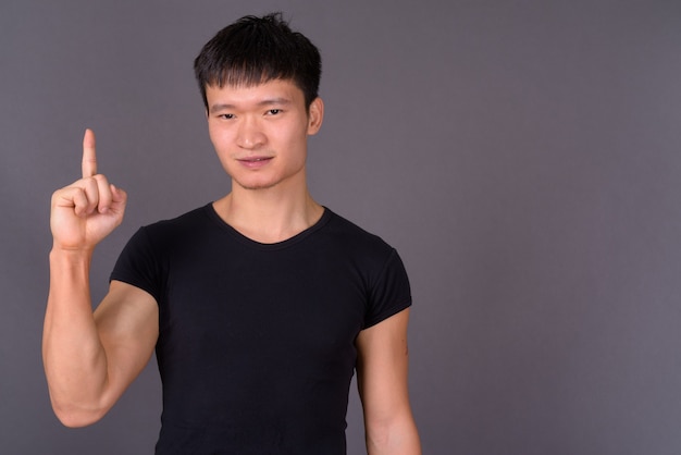 Studio shot of young man against gray