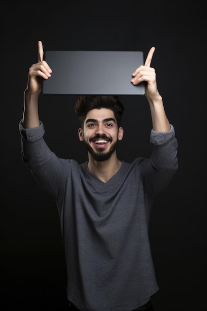 Studio shot of a young man holding up a digital tablet against a grey background