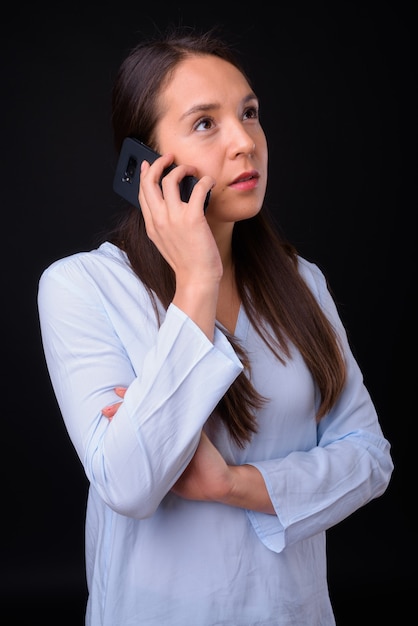 Studio shot of young multi ethnic beautiful businesswoman against black background