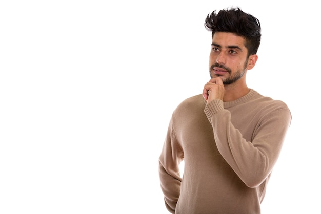 Studio shot of young Persian man thinking