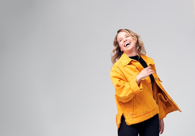 Studio Shot Of Young Woman Against White Background Having Fun Dancing