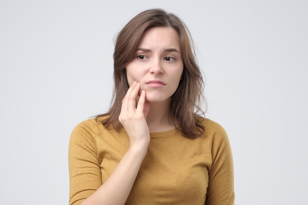 Studio shot of young woman with tooth pain