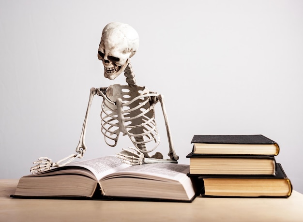 Study burnout Skeleton sitting at table with books stack Mental and physical exhaustion fatigue stress from prolonged concentration on education Preparing for exams