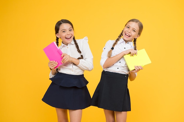 Study together Knowledge day School day Girl with copy books or workbooks Kids cute students Schoolgirls best friends excellent pupils School friendship Schoolgirls wear school uniform