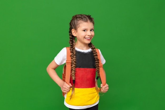 Studying abroad learning German a little girl with textbooks and a briefcase on an isolated background