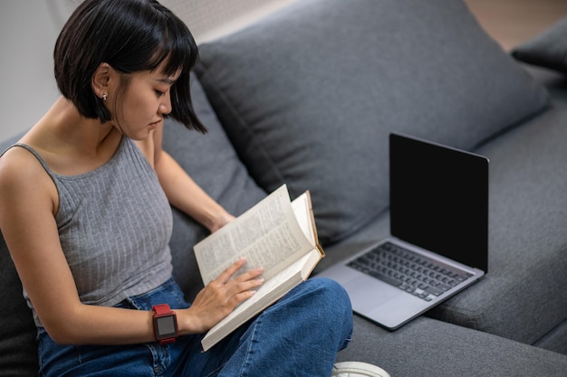 Studying from home. Asian young girl sith a book studying at home