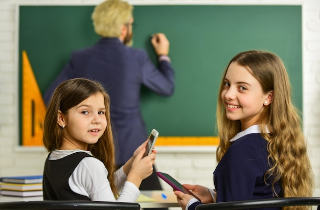 Studying hard disclose and develop creativity Teacher working with Creative Kids small girls children at school back to school Teacher and pupil working at desk together at the elementary school