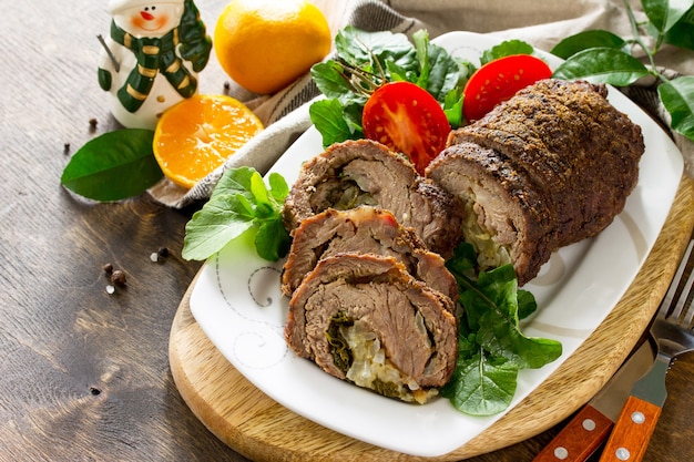 Stuffed Beef Roll with Pear and Cheese on a festive Christmas table Copy space