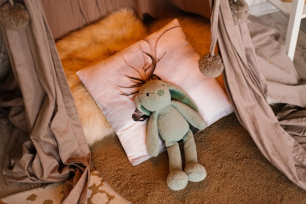 Stuffed bunny toy lies on a pillow on the bed in the children's room