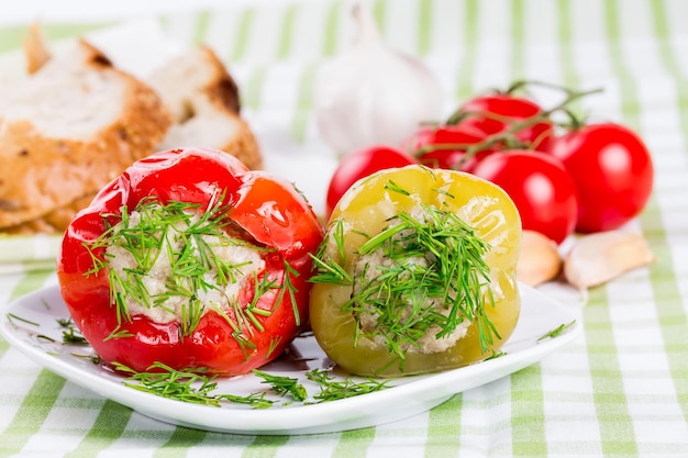 Stuffed red and green peppers on a white plate