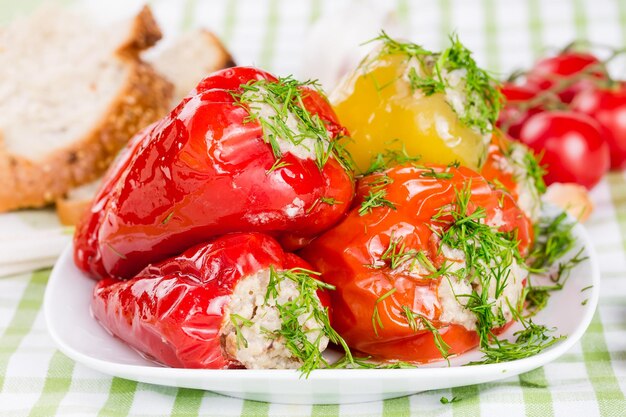 Stuffed red and green peppers on a white plate