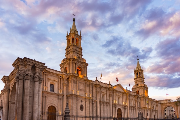 Stunning colorful sky and clouds at dusk in Arequipa, famous travel destination and landmark in Peru. Wide angle view from below of the colonial Cathedral. Panoramic frame.