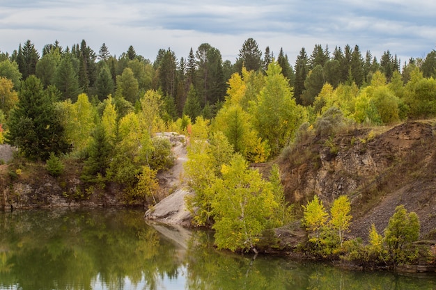 Stunning photo of fall foliage reflected on a lake with a glass like mirror water surface.