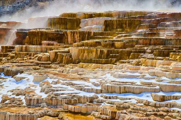 Stunning terrace layers of all colors in Yellowstone hot springs with steam